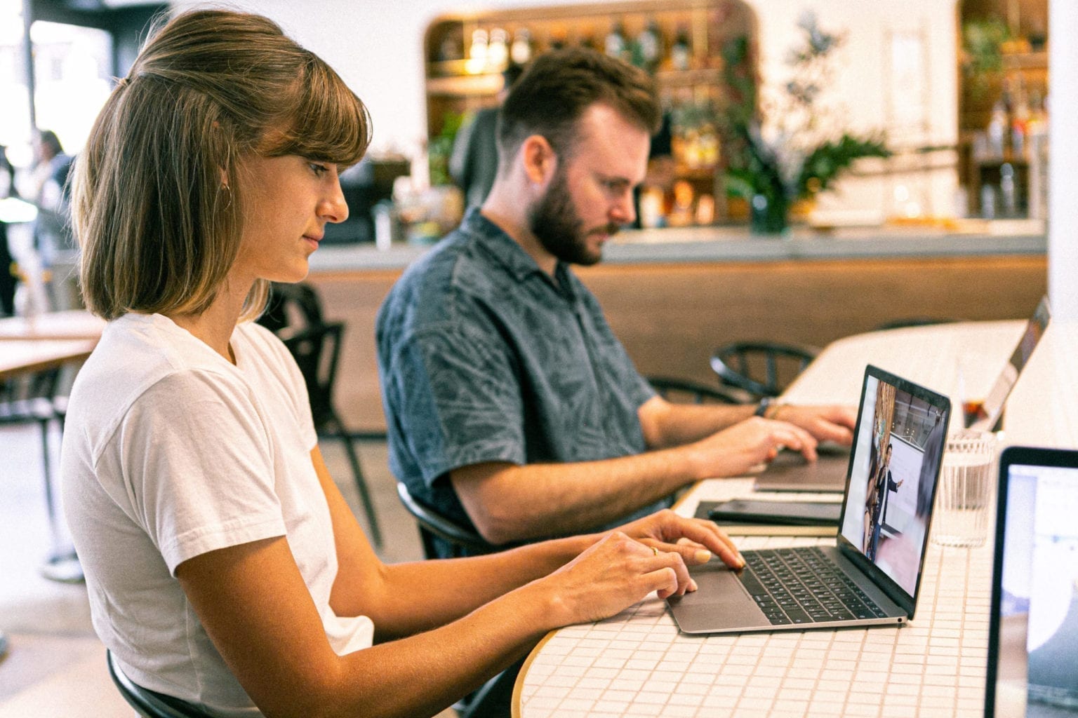 two people typing on a computer